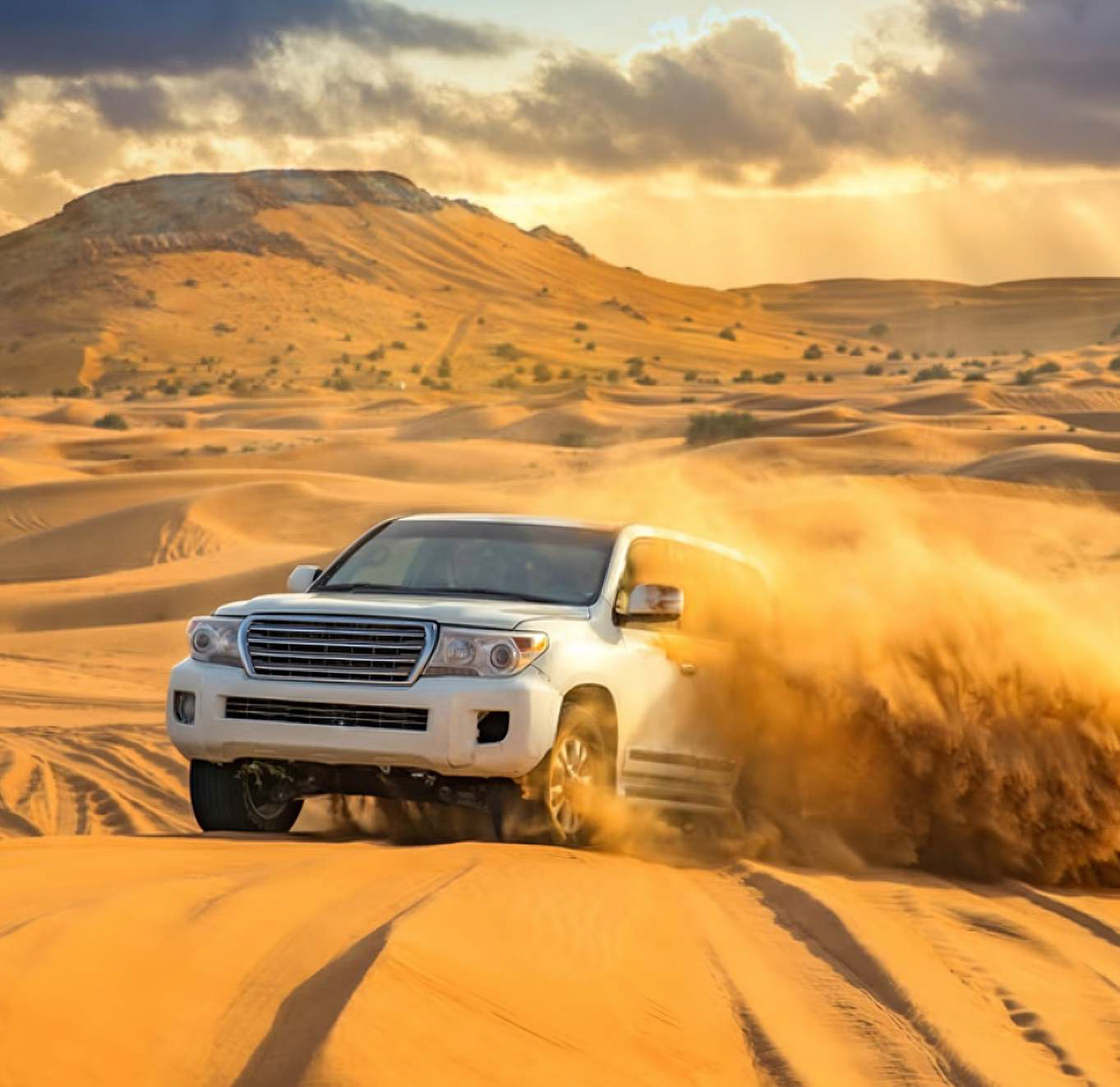 4x4 desert safari in Dubai driving across golden sand dunes at sunset