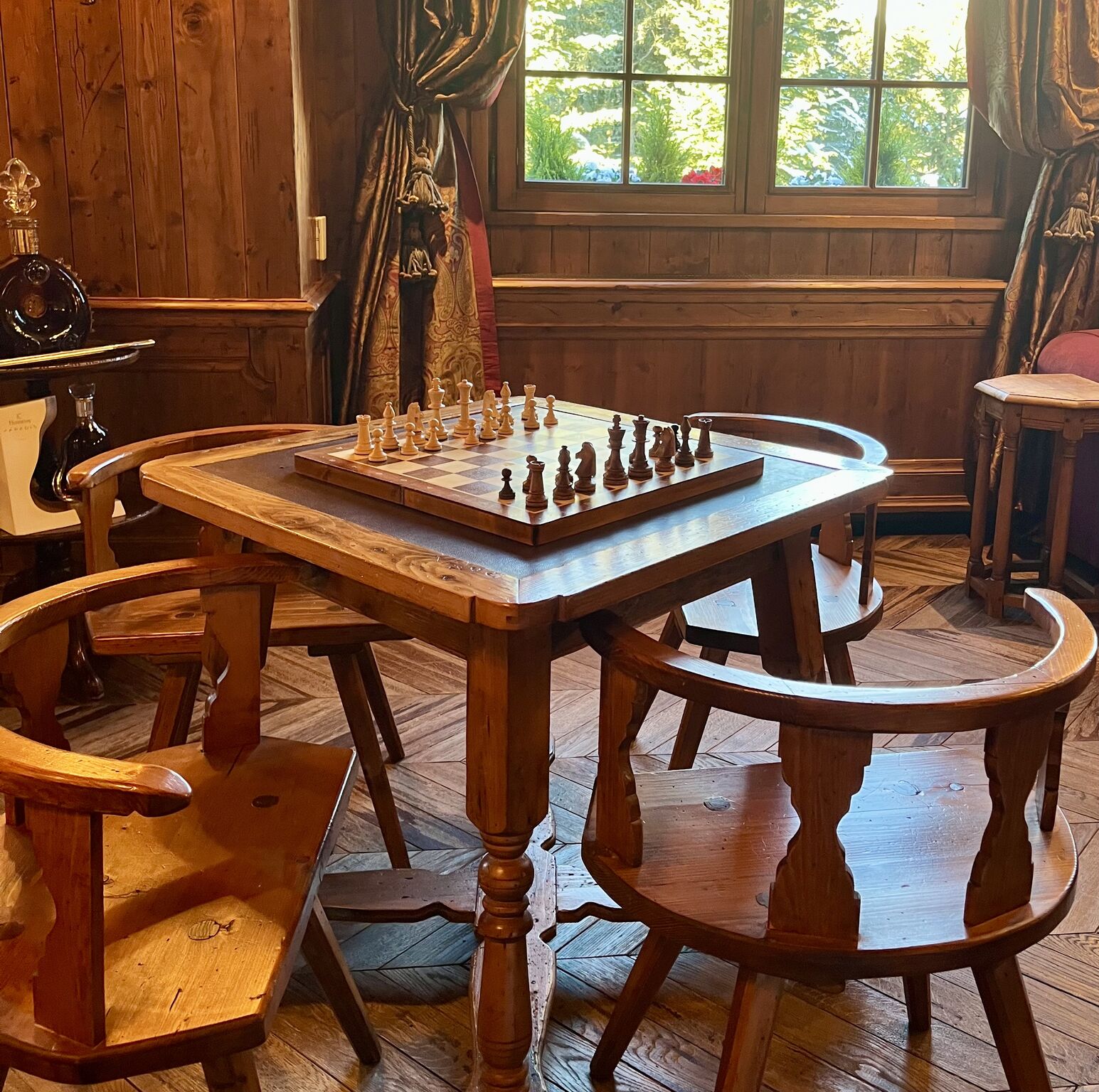 Immersive leadership retreat setting with a chess board on a wooden table in an intimate alpine-style interior