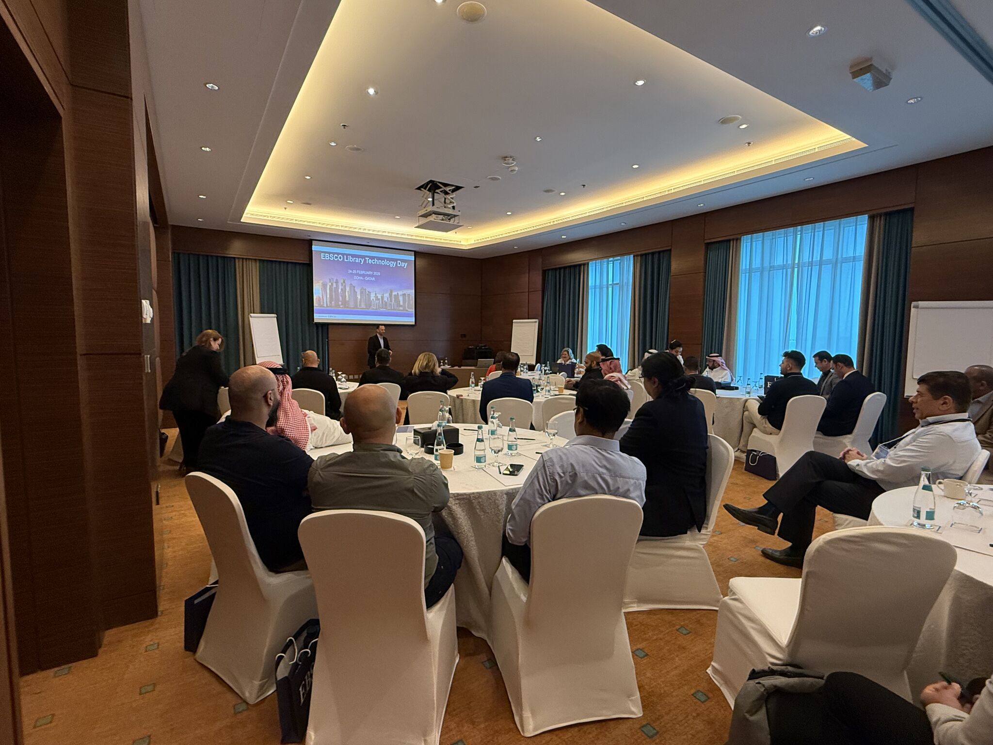 EBSCO Day conference in Doha with business professionals attending a seated presentation in a modern meeting venue