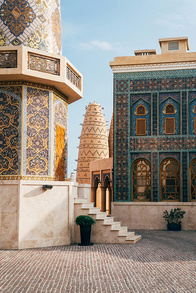 Traditional Qatari architecture with ornate blue tilework and historic wind towers in Doha