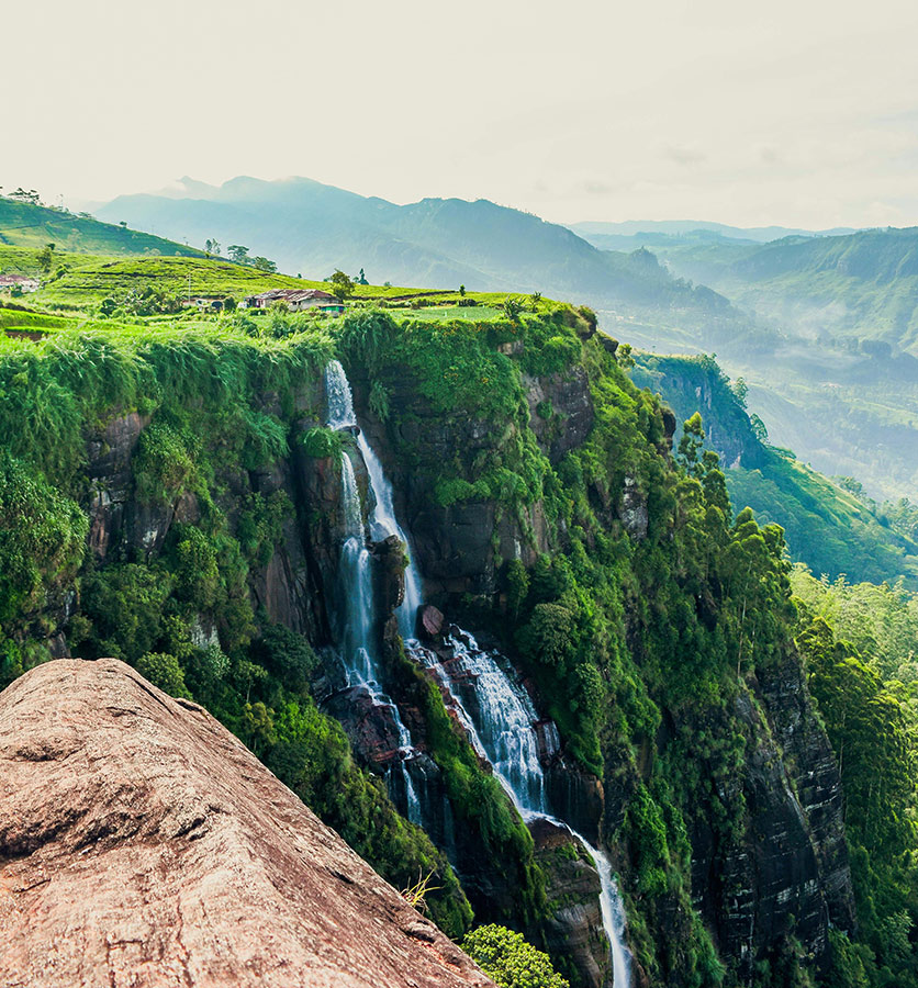 Waterfall cascading down lush green cliffs in Sri Lanka’s hill country